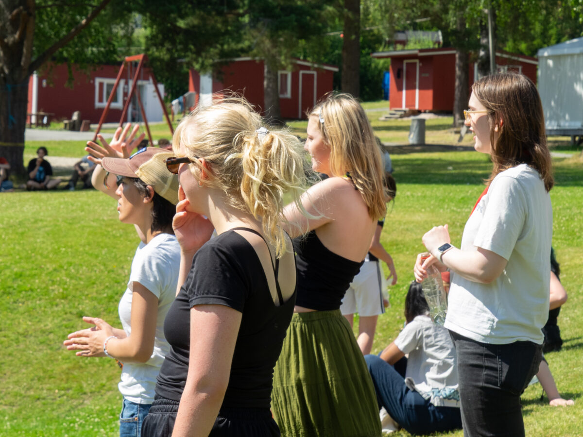 Fire jenter ser på en fotballkamp